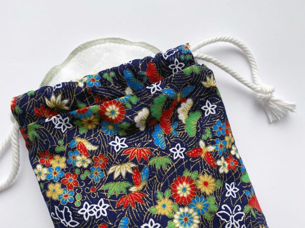 A close-up of the bag with a reusable makeup remover pad peeking out the top