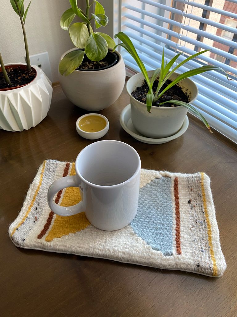 The mug rug on the table again, with a plain white mug sitting in the center. There’s room for a second mug