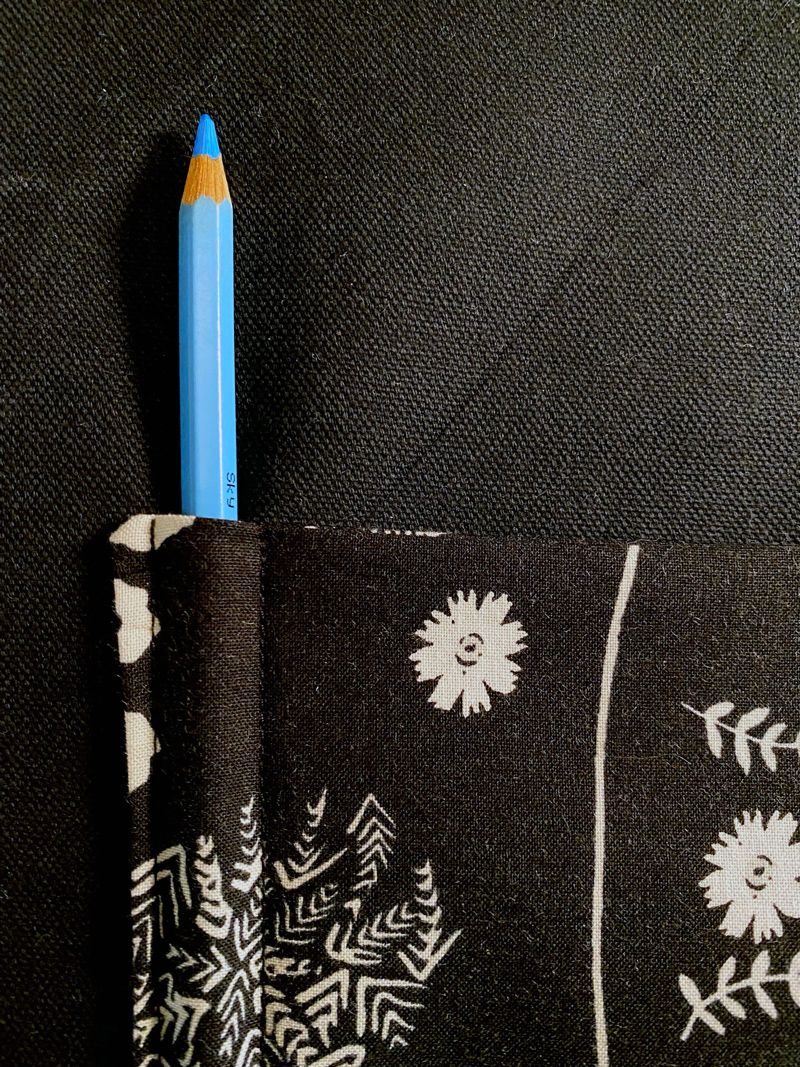 A blue pencil with one lined sewn after it. No other pencil slots are sewn yet.